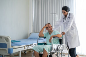 The african american doctor is pushing the wheelchair And provide consultation regarding treatment to patients sitting in a wheelchair and closely monitor